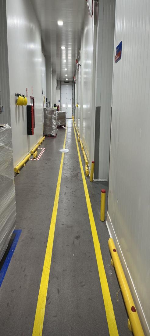 Pasillo de planta con demarcación de piso en línea doble amarilla